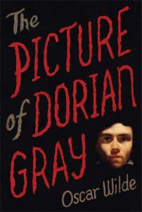 A poster reading The Picture of Dorian Gray by Oscar Wilde and a small human face.