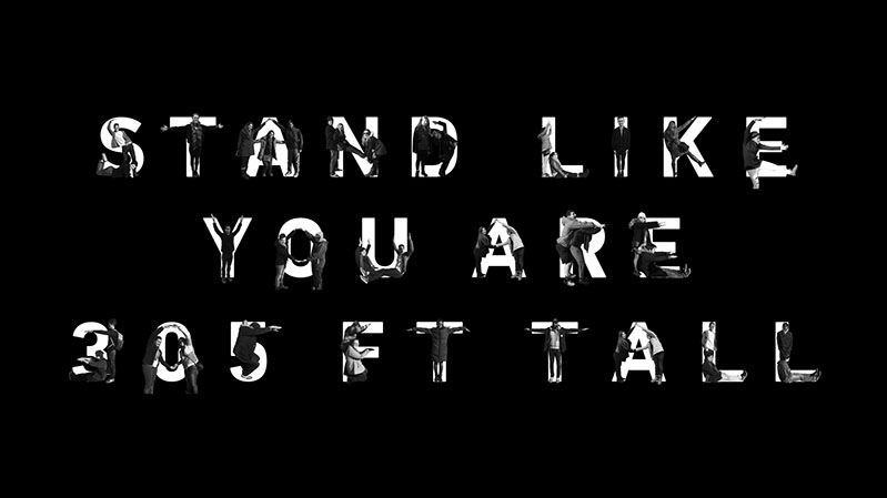A black and white picture showing some text with some people figures over each letter. The title: Stand like you are 305 FT tall.
