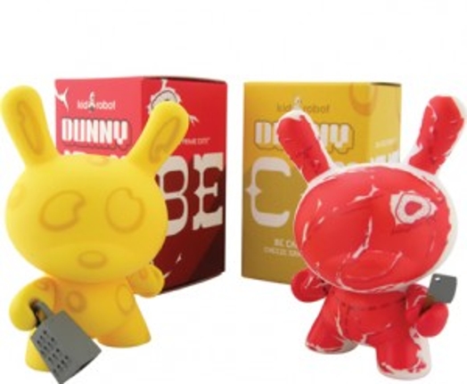 A picture of two red and yellow figurines that look like bunnies. Also behind them there are a red and a yellow box and the yellow figurine has a grater.