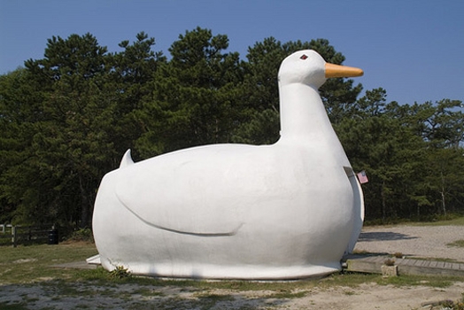 A photo of a white goose made from fiberglass with an entrance on its belly.