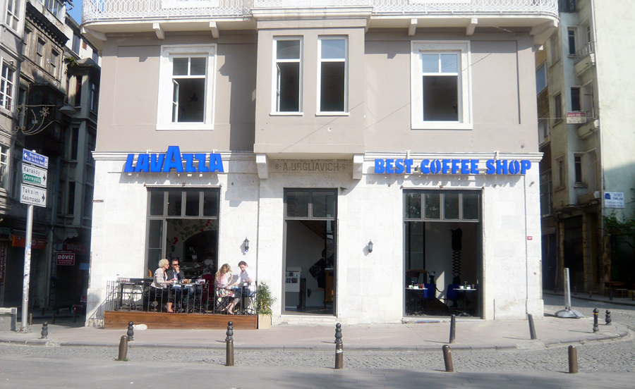 A photo of a side of the  building that has a blue text on it which says: Lavazza Best coffee shop.