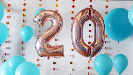 A photo of blue balloons and the number twenty made also from shiny balloons.