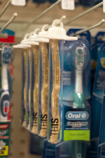 A photo of a bunch of wrapped sticks near a pack of toothbrushes.