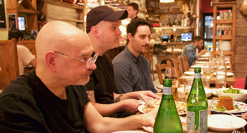 A photo showing people chatting at a restaurant table.