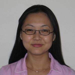 A photo of a woman wearing glasses and a pink shirt.