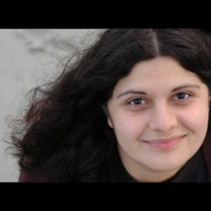 A photo of a woman wearing a black blouse.
