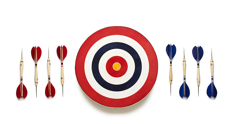 A dart target with concentrically colored circles and some darts arrows with red and blue tails that arranged one pointing up and the other pointing down.