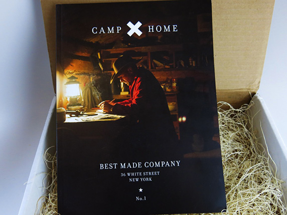 A book cover with a man sitting at a desk near a lamp. The title of the book: CAMP X HOME Best Made Company.