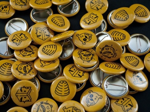 A photo of a pile of yellow pins with different pictograms on them.