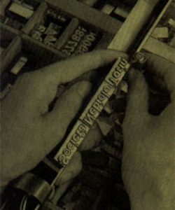 A black and white photo of two hands trying to align some iron letters for a printing press.