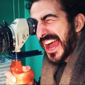 A man looking trough an optical finder.