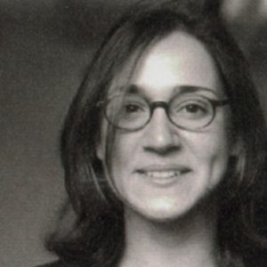 A black and white photo of a woman wearing glasses.