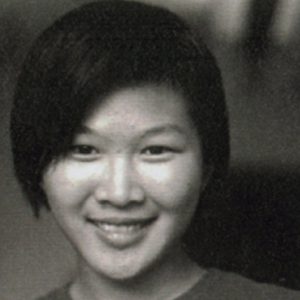 A black and white photo of a woman smiling.
