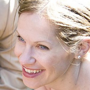 A photo of a woman smiling in the sun.