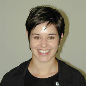 A photo of a smiling woman wearing a black coat.