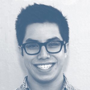 A black and white photo of a man wearing glasses and smiling.
