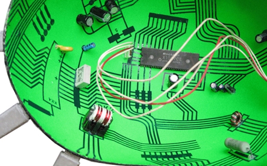 A 3d warped image of a green electronic board with different components on it.