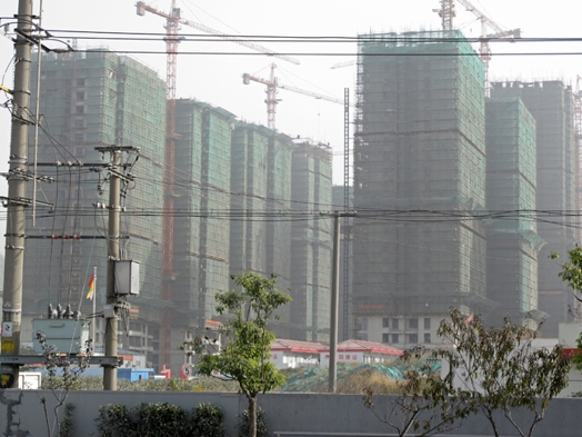 A photo of some cranes and some tall buildings being raised.