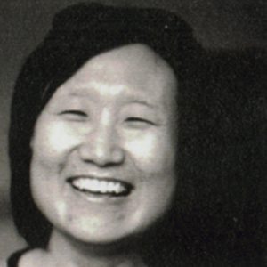 A black and white photo of a smiling woman.