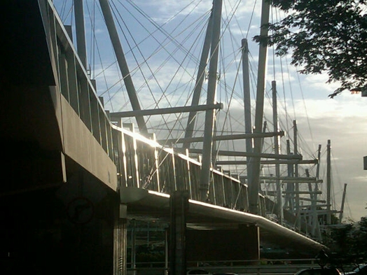 A photo of a white bridge suspended by cables.