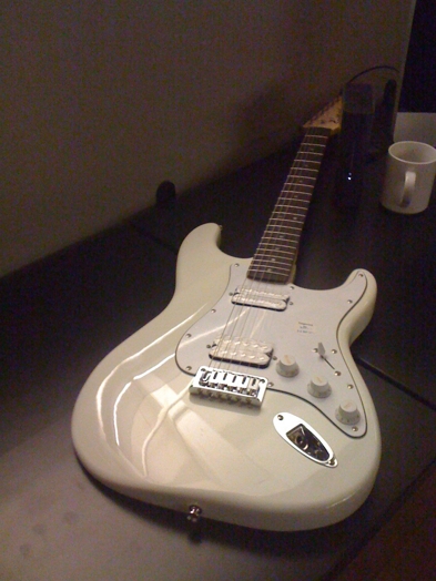 A photo of a marble white colored guitar.