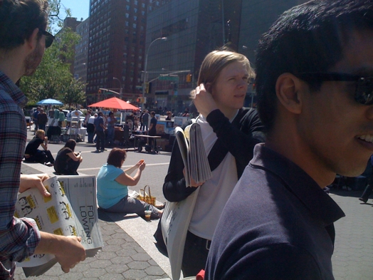 A photo of a group of people distributing flyers on the street.