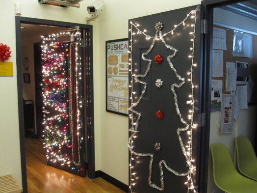 A photo of Christmas garlands and light decorations on doors.
