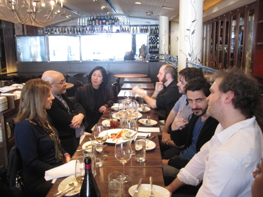A photo of a group of people sitting next to each other at a restaurant table.