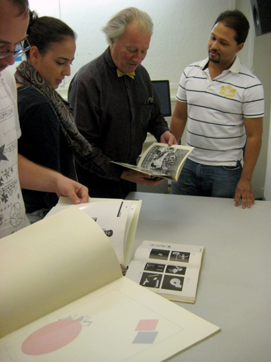 A photo of a group of people looking trough some artbooks.