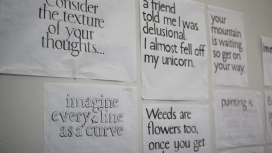 A photo showing papers with different styles of text, glued to the wall.