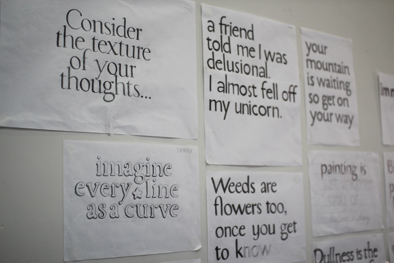 A photo showing papers with different styles of text, glued to the wall.