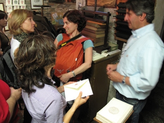 A photo of a group of people talking while one of them has an envelope in her hand.