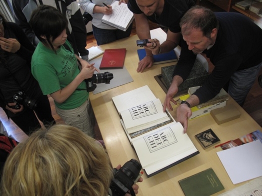A photo of a group of people checking fonts in a printed books.