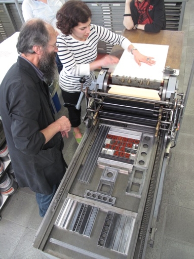 A photo of people working at a typography machine.