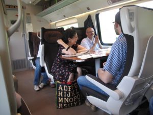 A photo of three persons sitting comfortable in a bullet train.