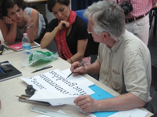A photo of a teacher that shows the typographical letters on a piece of papers.
