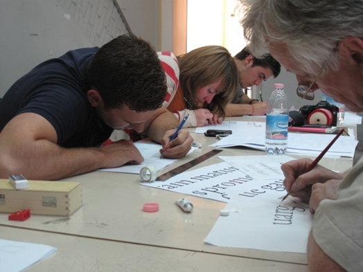 A photo of agroup of students learning to draw letters.