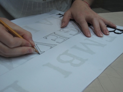 A photo of a letter being drawn by a student on a piece of paper.