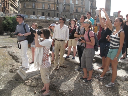 A photo of a group of people visiting old buildings in Rome.