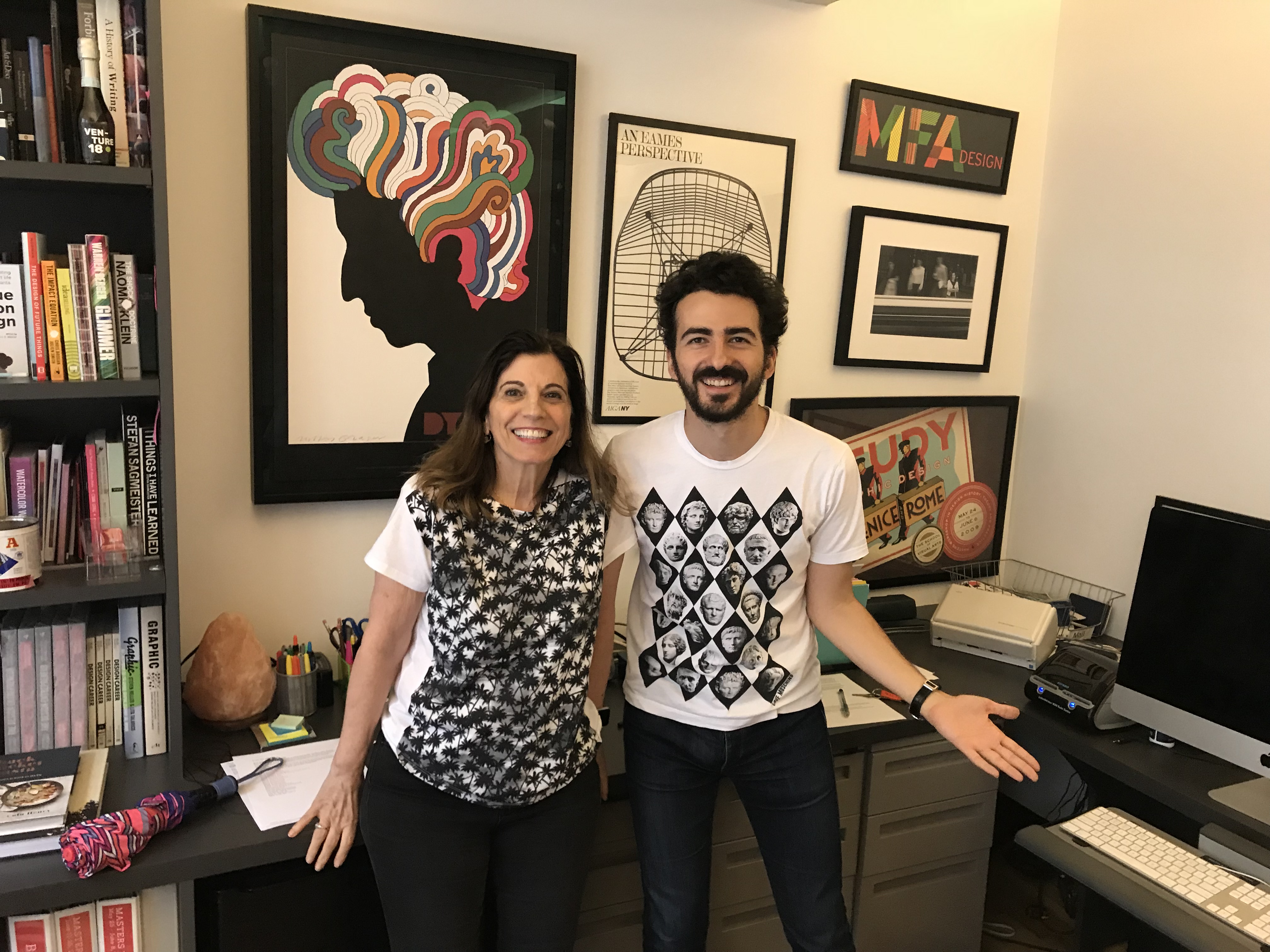 A photo of a man and a woman smiling in an office.