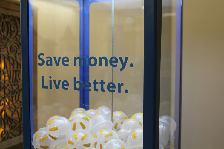 A photo of a vending machine with rubber balls in it and on the side glass the text: Save money. Live better.