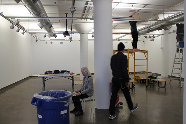 A photo showing people working to set up an art gallery.