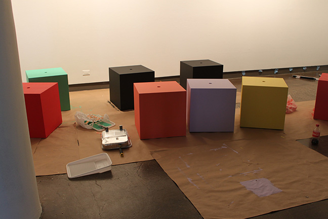 A set of cubical tables with different colors and a hole in the middle.