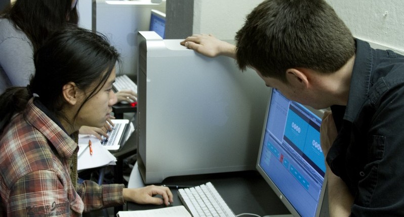 A photo of a man and woman looking at a computer.