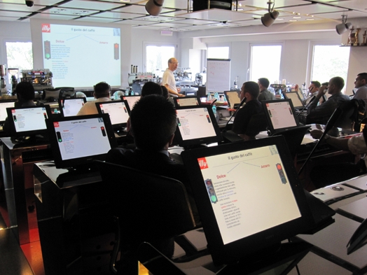 A photo of a classroom with computers and a screen projector.