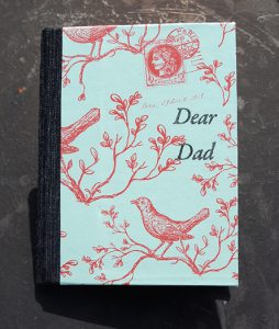 A notebook cover showing red sketches of birds and plants on a cyan background.