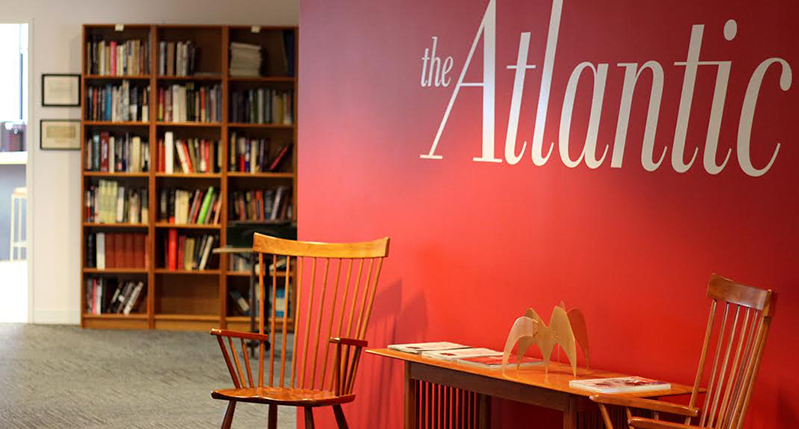 A photo of what looks like a library near a red wall with the white text: The Atlantic.
