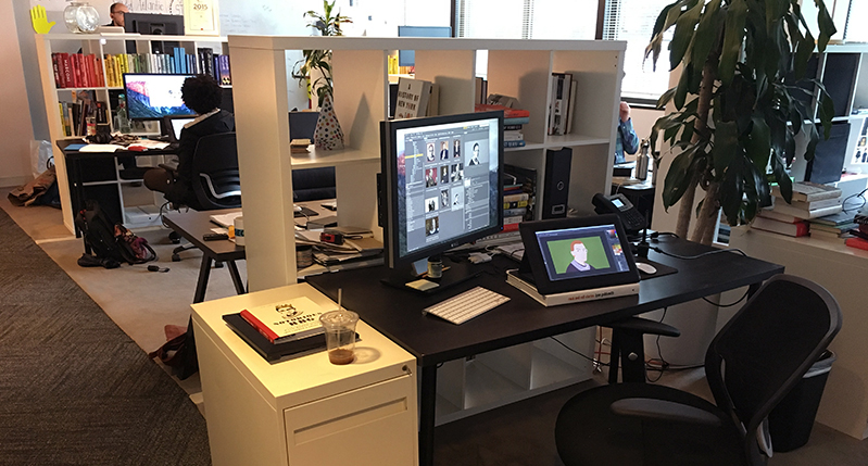 A photo of a digital art workshop with desks, tablets and computer stations.