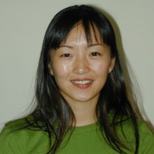 A photo of a smiling woman wearing a green shirt.