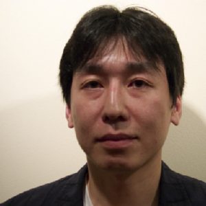 A photo of a man wearing a black blouse.